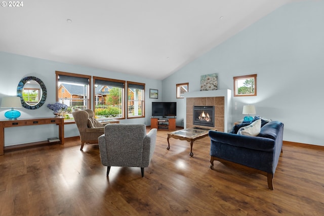 living room with high vaulted ceiling, hardwood / wood-style floors, and a tile fireplace