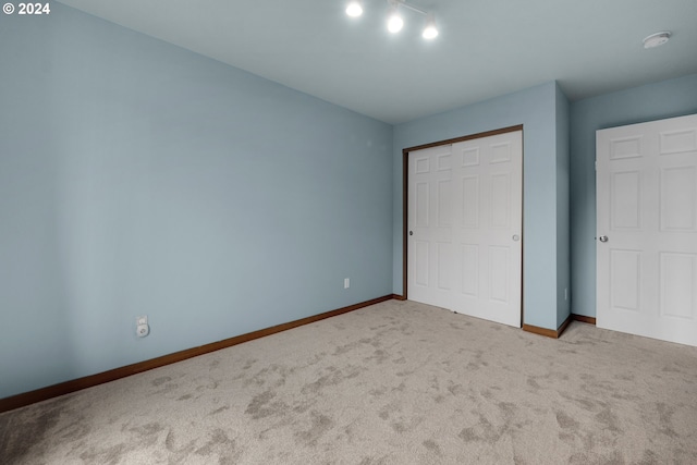 unfurnished bedroom featuring light carpet and a closet