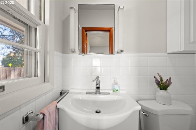 bathroom featuring sink, tile walls, and toilet