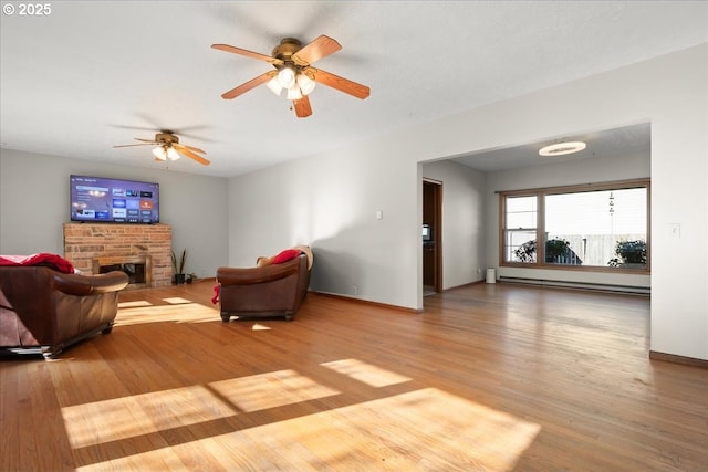 living room featuring hardwood / wood-style flooring, a fireplace, and baseboard heating