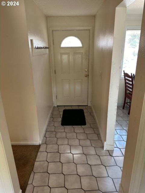 doorway with light tile patterned flooring