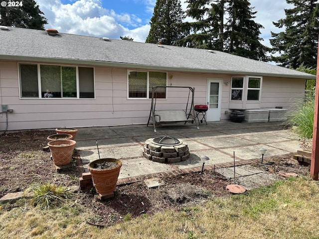 back of property with a patio and an outdoor fire pit