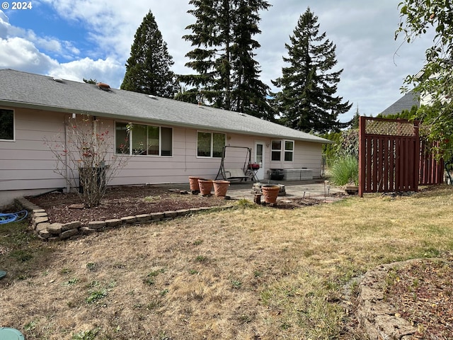 back of property featuring a lawn and a patio