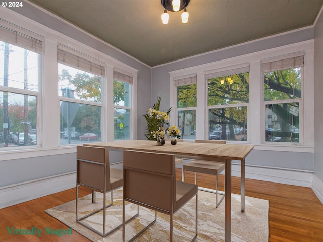 dining space featuring crown molding, light wood-type flooring, and a healthy amount of sunlight