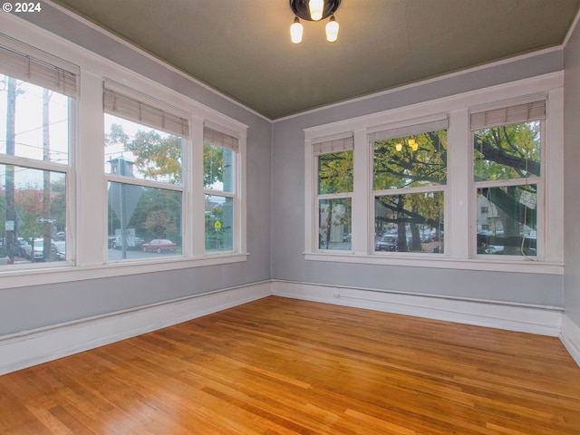 spare room with light wood-type flooring and crown molding