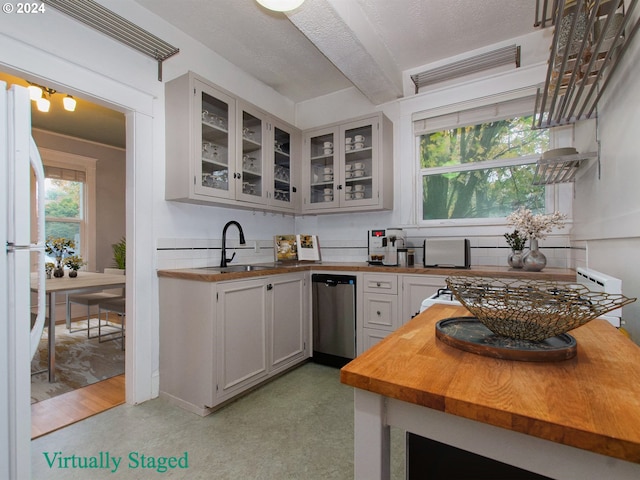 kitchen with stainless steel dishwasher, white refrigerator, wood-type flooring, white cabinetry, and sink