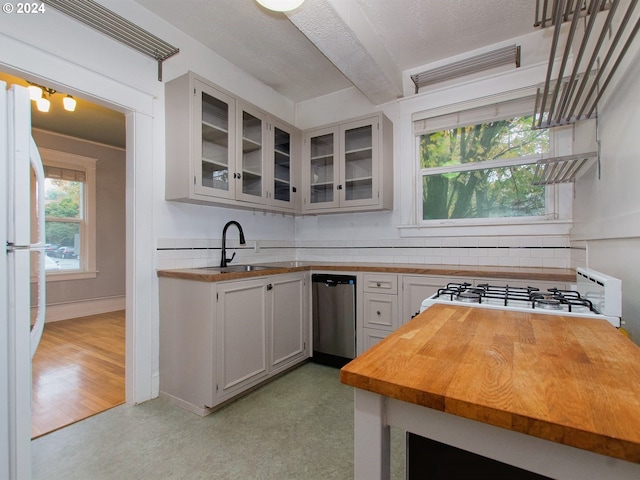 kitchen featuring sink, concrete flooring, white cabinets, stainless steel dishwasher, and white refrigerator