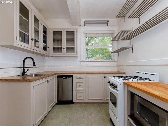 kitchen featuring sink, white cabinets, backsplash, stainless steel appliances, and butcher block counters