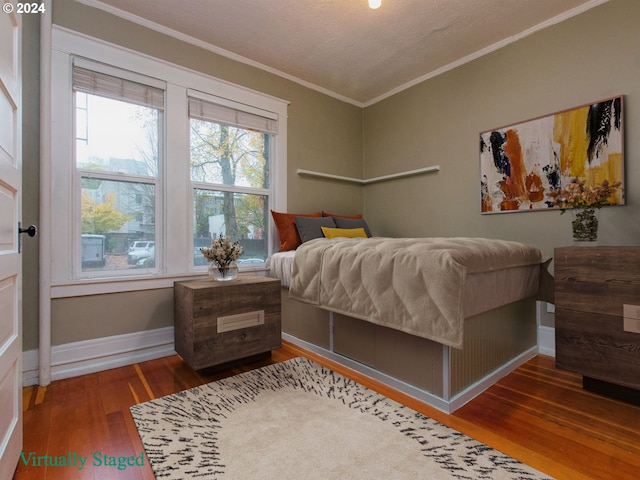 bedroom featuring crown molding, dark hardwood / wood-style floors, and a textured ceiling