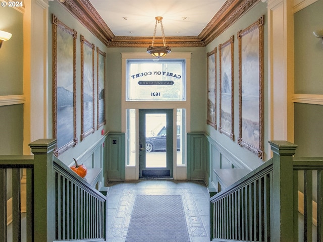 entrance foyer featuring crown molding and light tile floors