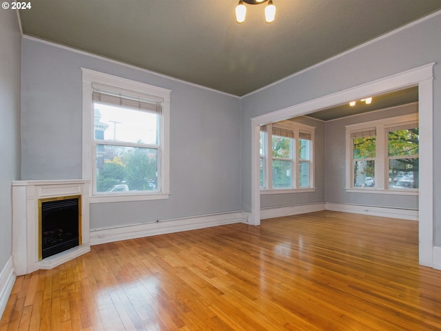 unfurnished living room featuring crown molding and light hardwood / wood-style floors