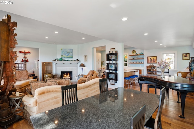 dining area featuring hardwood / wood-style floors and a tile fireplace