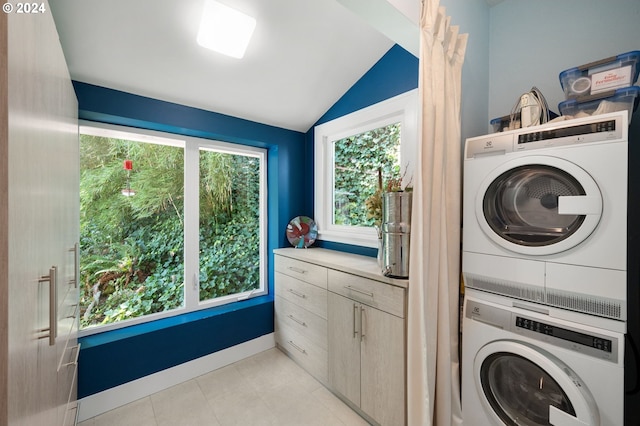 washroom with light tile patterned flooring and stacked washer and clothes dryer