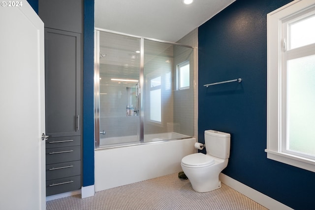 bathroom featuring enclosed tub / shower combo, tile patterned floors, and toilet