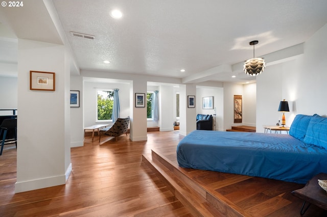 bedroom featuring hardwood / wood-style flooring and a textured ceiling