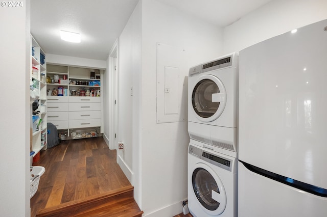 laundry area with stacked washer / dryer and dark wood-type flooring