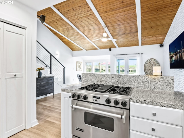 kitchen with high end stove, wood ceiling, light hardwood / wood-style flooring, lofted ceiling with beams, and white cabinets