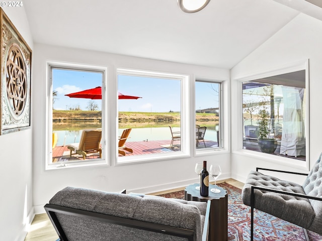 sunroom / solarium featuring a water view and vaulted ceiling