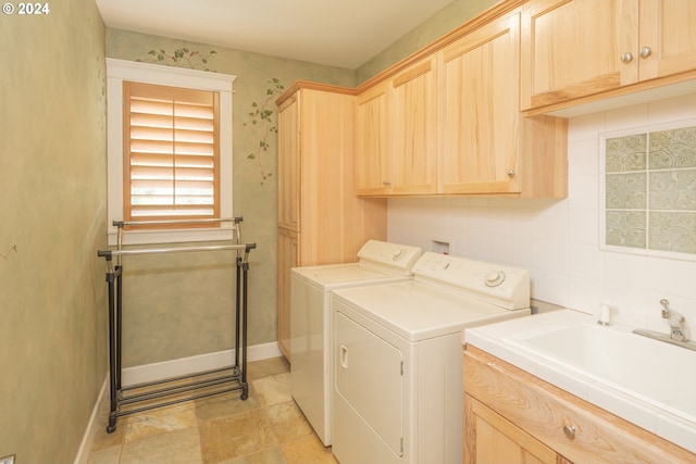 laundry area with washing machine and dryer, cabinets, and sink