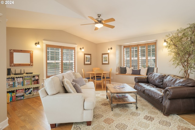 living room with light hardwood / wood-style floors, ceiling fan, and lofted ceiling