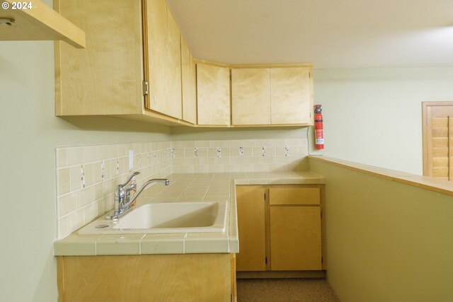 kitchen with decorative backsplash, sink, and tile counters