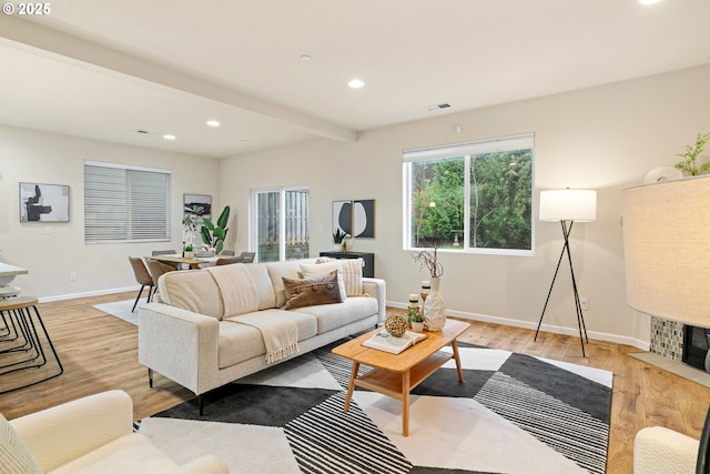 living room featuring light wood-type flooring and beam ceiling