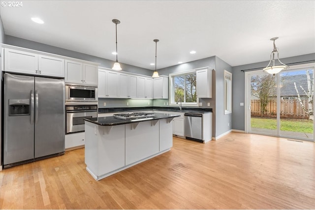 kitchen with pendant lighting, light hardwood / wood-style floors, white cabinetry, and stainless steel appliances