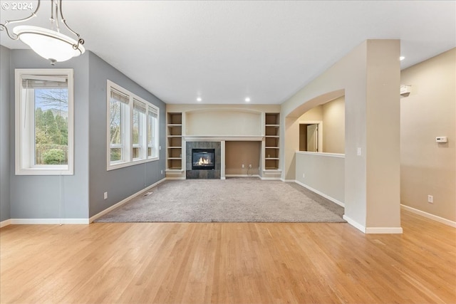 unfurnished living room featuring light wood-type flooring and a fireplace