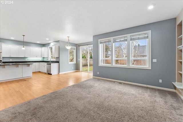 unfurnished living room with light hardwood / wood-style floors and sink