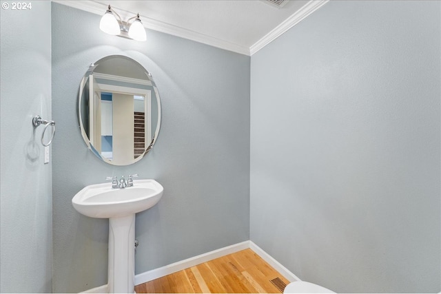 bathroom with hardwood / wood-style floors and ornamental molding