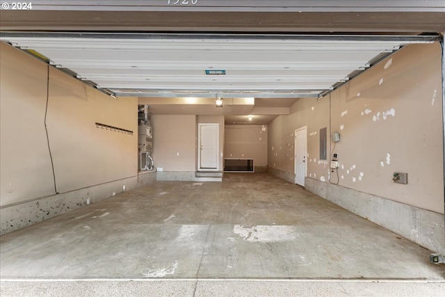 garage featuring secured water heater, electric panel, and a garage door opener