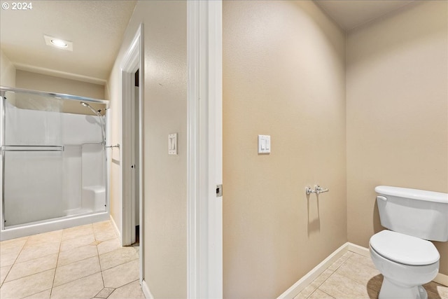 bathroom with tile patterned flooring, a shower, and toilet