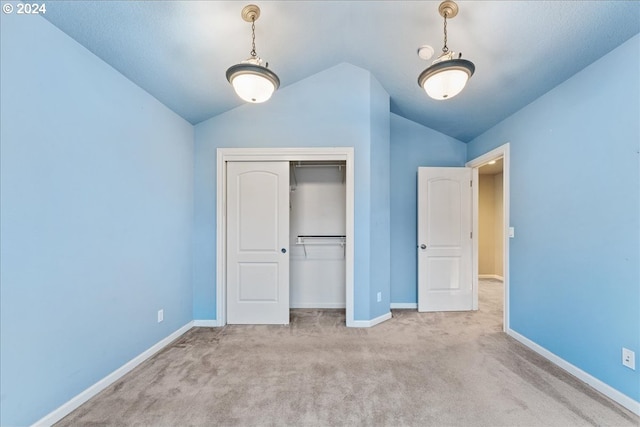 unfurnished bedroom with a closet, light carpet, and vaulted ceiling