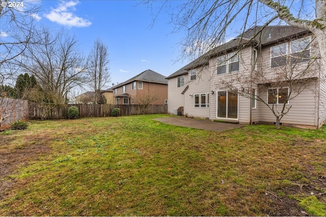 rear view of property with a yard and a patio area