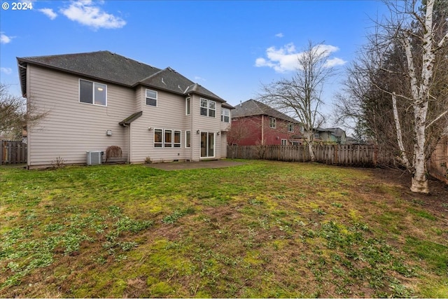 rear view of property with a yard, a patio, and central AC unit