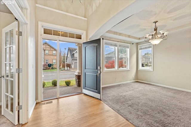 entrance foyer with light wood-type flooring and an inviting chandelier