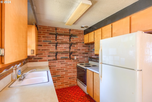 kitchen featuring white appliances, a textured ceiling, sink, and brick wall