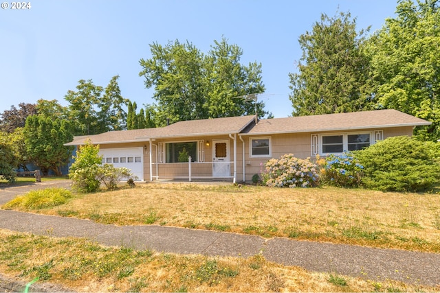 single story home with a garage, a porch, and a front lawn