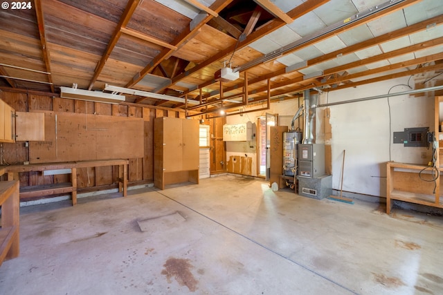 basement featuring electric panel, a workshop area, and gas water heater