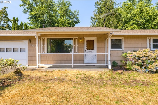 ranch-style home with a front yard, a garage, and covered porch