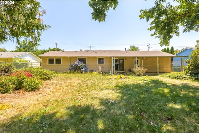 back of house with a lawn