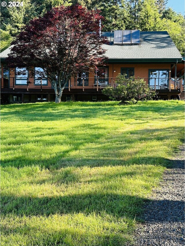 exterior space with a wooden deck and a front yard