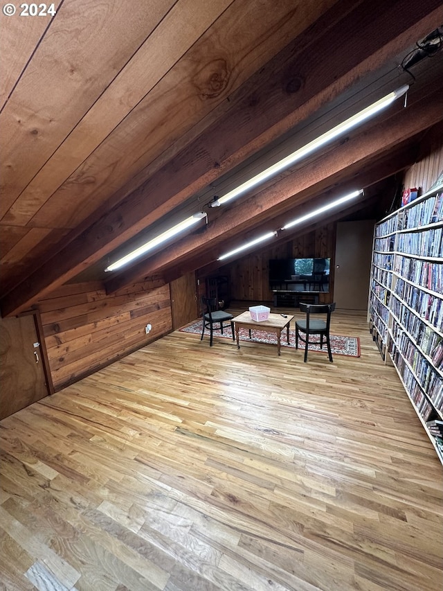 interior space with wooden walls, vaulted ceiling with beams, wooden ceiling, and light wood-type flooring