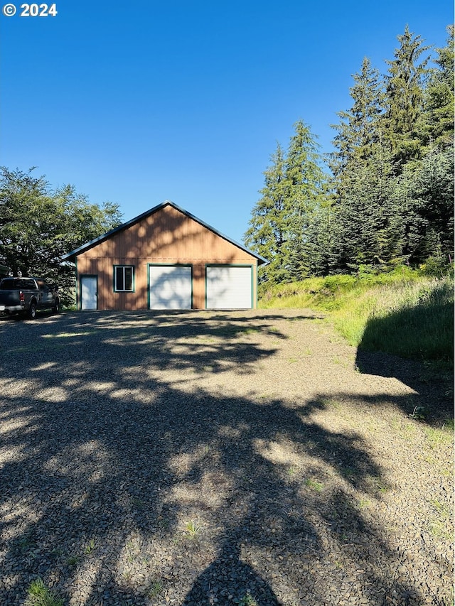 view of side of property with a garage and an outbuilding