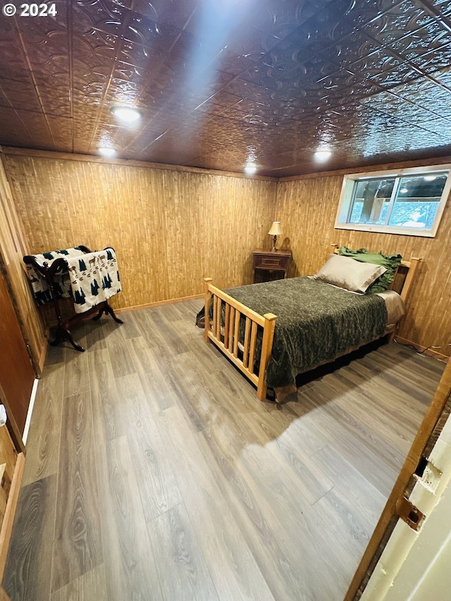 bedroom with wood walls and hardwood / wood-style floors