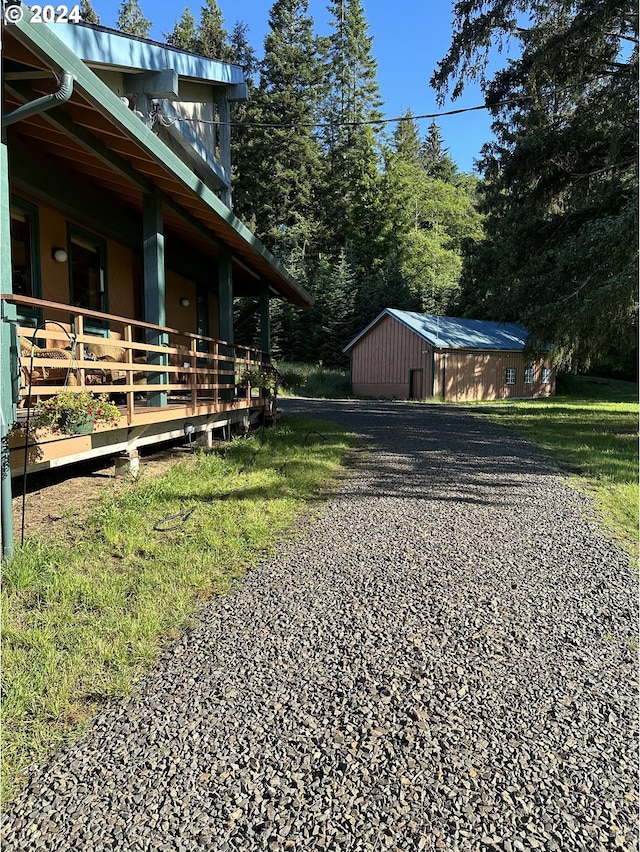 view of yard featuring a balcony and an outdoor structure