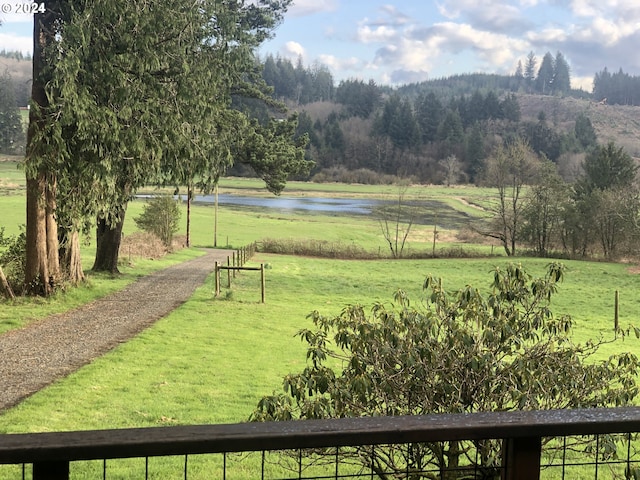 view of property's community featuring a lawn, a rural view, and a water view