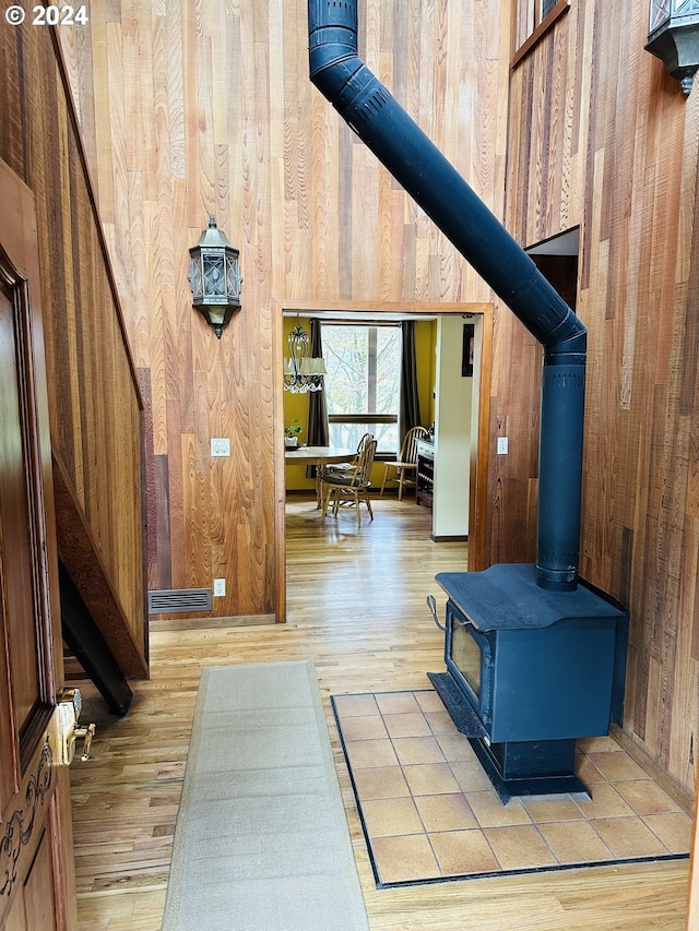 interior space featuring wood walls, light hardwood / wood-style flooring, and a wood stove