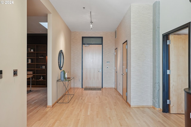 corridor featuring light wood-type flooring and rail lighting