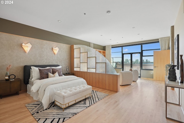 bedroom with a water view and light wood-type flooring